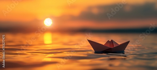 A small children's yellow red boat sails on the sea against the background of the sunrise © Ibad