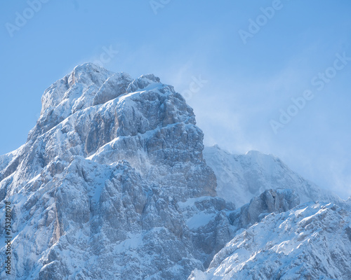 Snow-capped sunlit peak in Krnica Valley, Julian Alps on a clear winter day