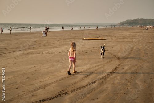 walking on the beach. Child and dog in Arambol photo