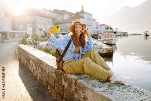 Happy tourist walks the streets and takes selfie using smartphone camera. Lifestyle, adventure, nature, active life.