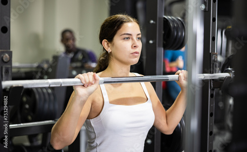 Athletic woman doing barbell exercises in the gym