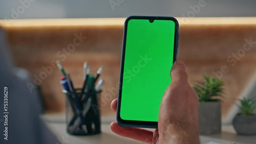 Unknown guy looking chroma key cellphone working at company office alone closeup photo
