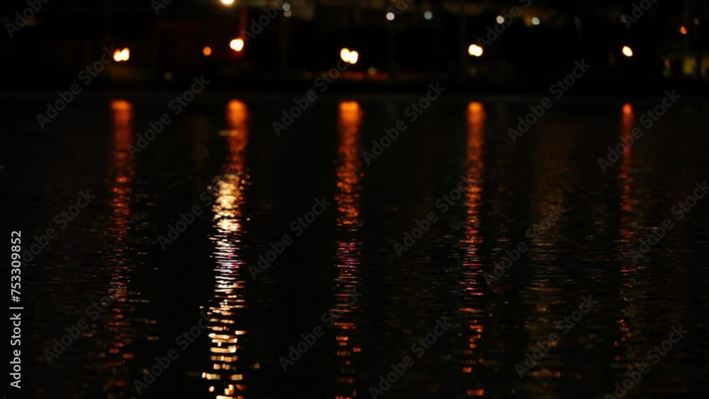 Orange lights reflecting in shimmering water - locked off shot Orange lights reflecting in shimmering water - locked off shot