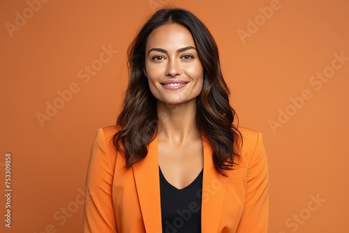Portrait of a smiling business woman in orange jacket over orange background