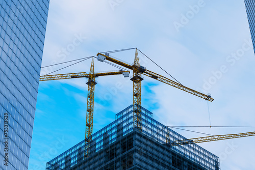 Soaring Cranes Over Sprawling Construction Site Amidst City Skyline