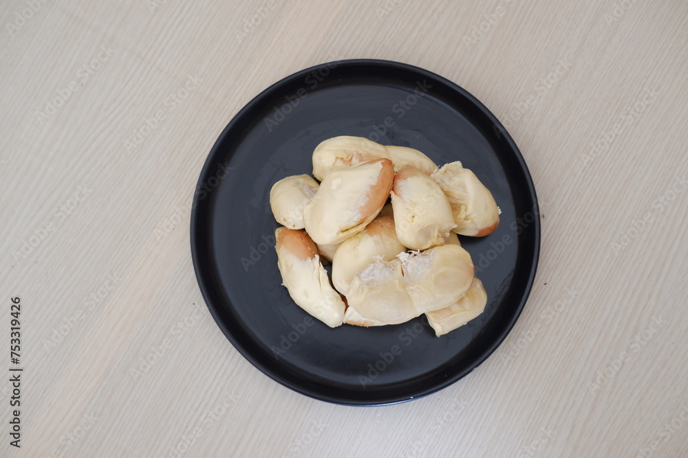 Durian riped and fresh ,durian peel on black plate Durian riped and fresh ,durian peel on black plate