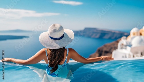 Beautiful women on vacation at Santorini relaxing in swimming pool looking out over ocean. 