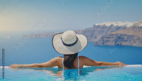 Beautiful women on vacation at Santorini relaxing in swimming pool looking out over ocean