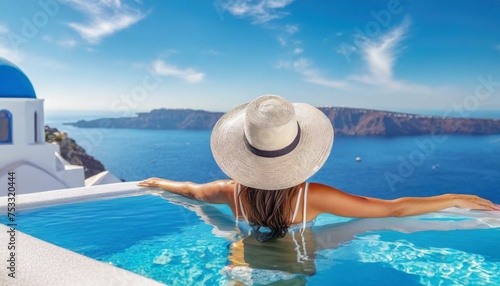 Beautiful women on vacation at Santorini relaxing in swimming pool looking out over ocean