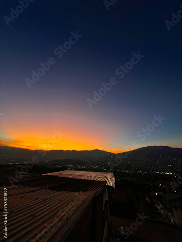 Colorful sunset with blue and orange sky. View of the city of Medellin.