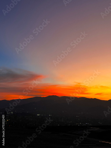 Colorful sunset with blue and orange sky. View of the city of Medellin.