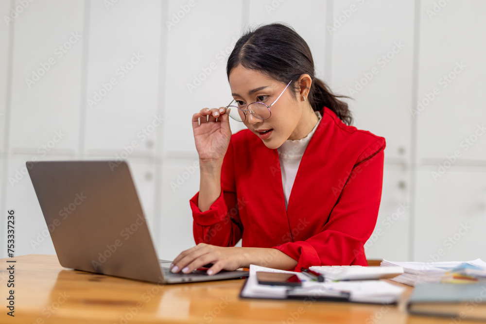 Portrait of Happy young business asian woman in red suit sitting at her desk in the office business finance concept. Portrait of Happy young business asian woman in red suit sitting at her desk in the office business finance concept.