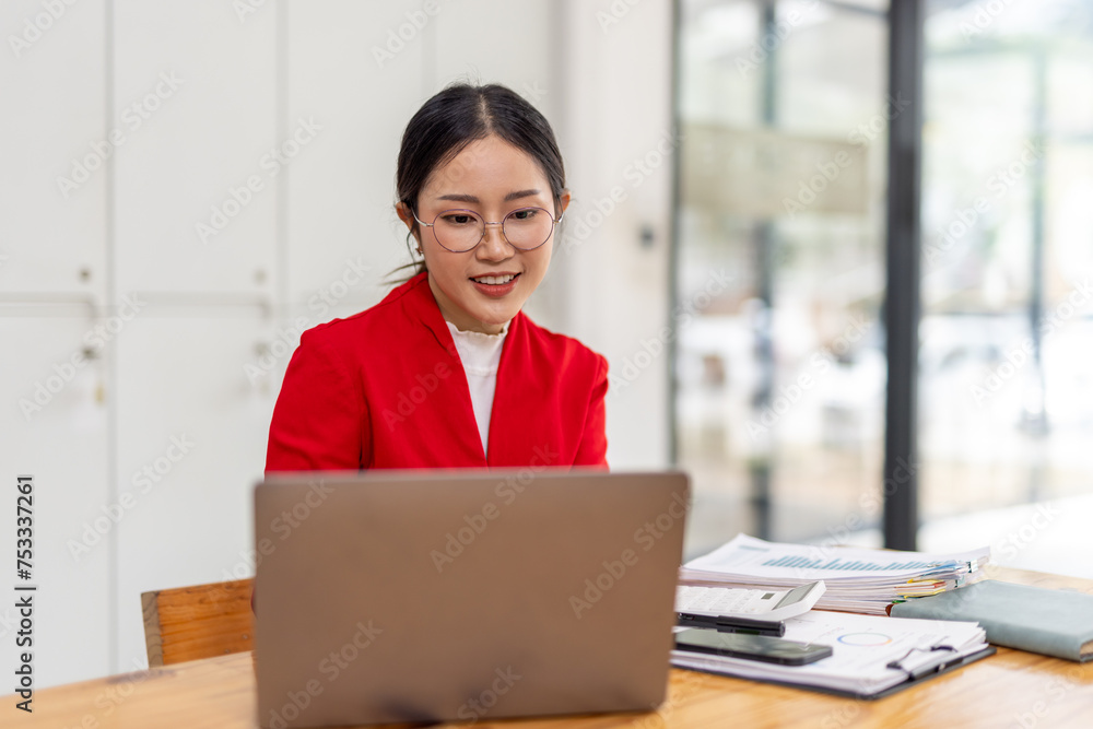 Portrait of Happy young business asian woman in red suit sitting at her desk in the office business finance concept. Portrait of Happy young business asian woman in red suit sitting at her desk in the office business finance concept.