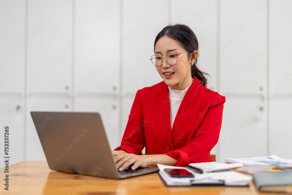 Portrait of Happy young business asian woman in red suit sitting at her desk in the office business finance concept. Portrait of Happy young business asian woman in red suit sitting at her desk in the office business finance concept.