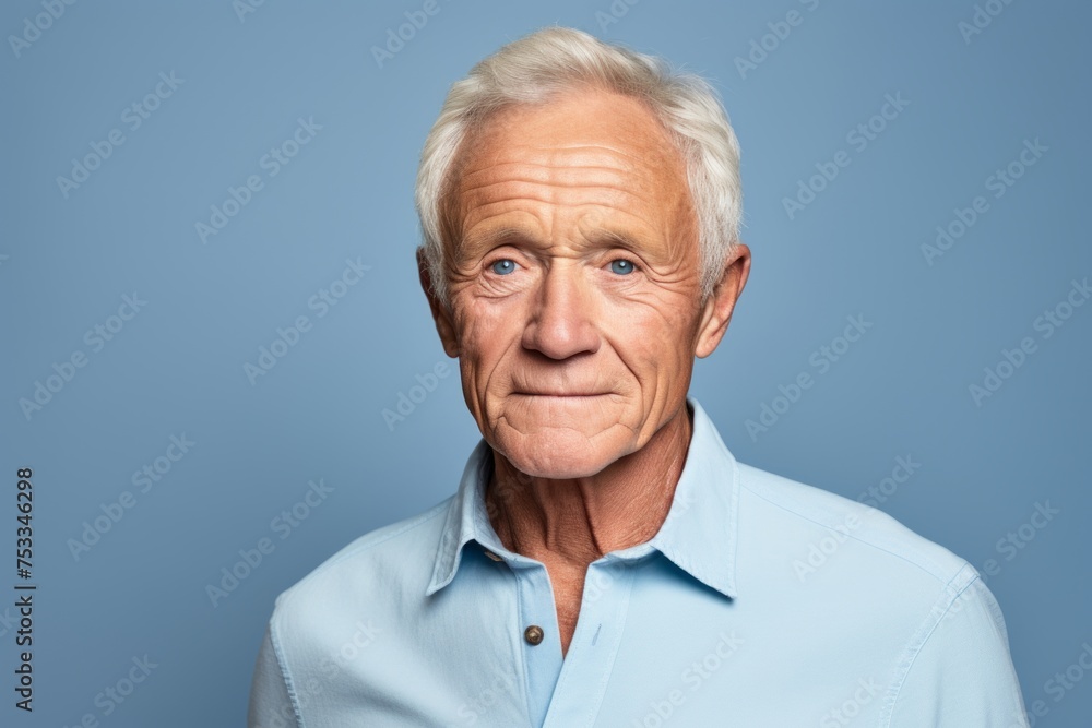 Portrait of senior man with grey hair and blue shirt on blue background Portrait of senior man with grey hair and blue shirt on blue background