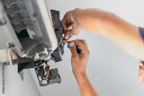 Technician checking thermistor, Repairman fixing air conditioning system, Technician service for repair and maintenance of air conditioners photo