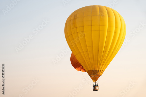 Yellow hot air balloon in flight against the sky.