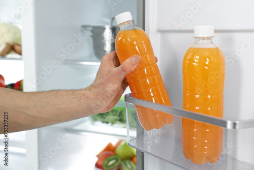 Man taking bottle of juice out of refrigerator, closeup