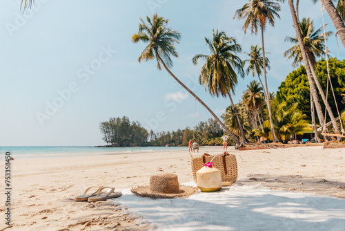 Beach and tropical paradise with a coconut resting on the sand and a refreshing coconut cocktail nearby beneath swaying palm trees