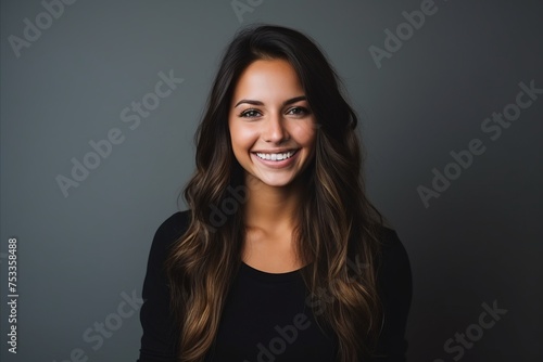 Portrait of a beautiful young woman smiling at the camera over grey background