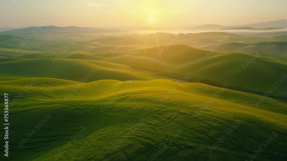Fototapeta premium Drone perspective of a serene countryside sunrise, with mist hovering over rolling hills