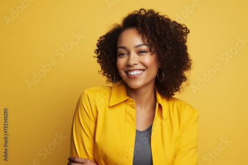 Smiling african american woman in yellow jacket on yellow background