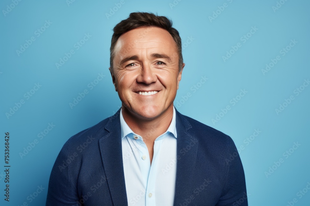Handsome middle aged man smiling at camera against blue background. Handsome middle aged man smiling at camera against blue background.