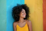Happy young woman leaning against a colorful wall 