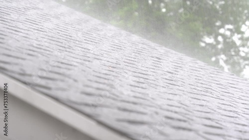 Slow motion of torrential downpour of rain on an asphalt roof.