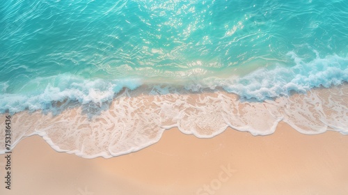 An abstract sandy beach seen from above, with clear blue water waves and sunlight, representing a summer vacation background concept for banners. © wpw