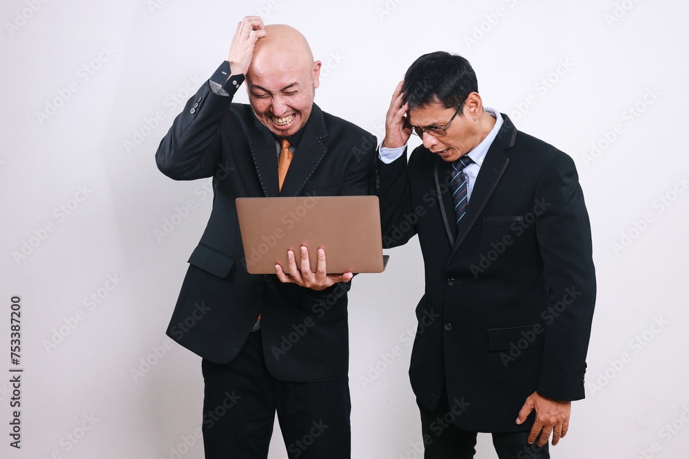 Failed business people with hands on head looking at laptop feeling frustrated. Business problem concept. Failed business people with hands on head looking at laptop feeling frustrated. Business problem concept.