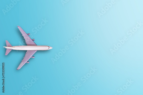 Top view of miniature white airplane on blue table background