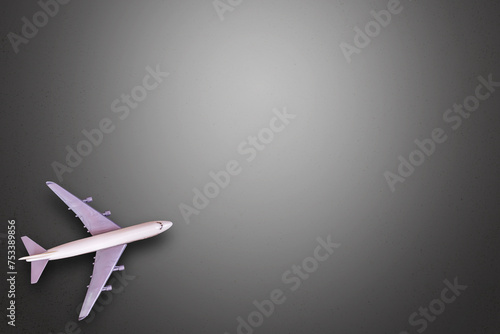 Top view of miniature white airplane on black table background