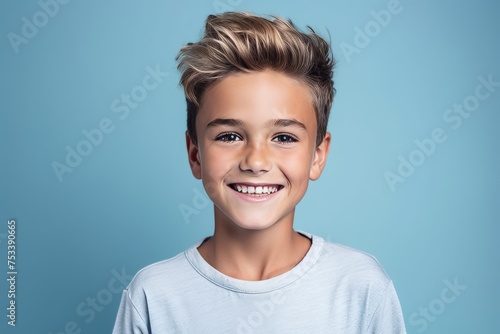 Portrait of a cute smiling little boy on a blue background.