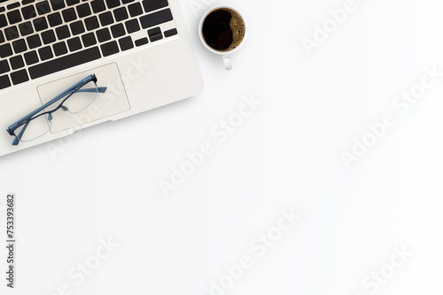 Office desk or workspace with laptop computer,cup of coffee and glasses