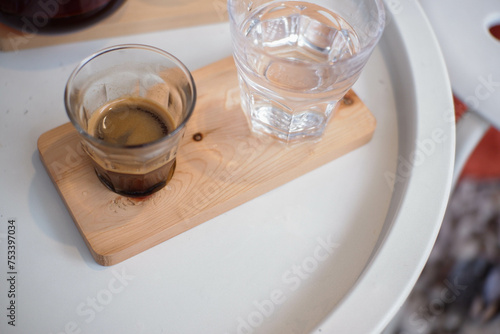 espresso and water on a wooden coaster on the table