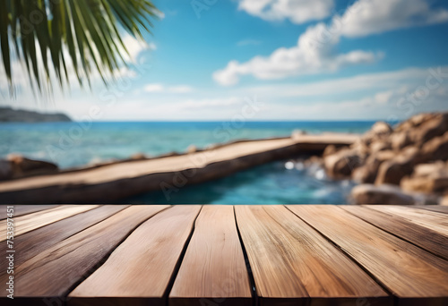 Tropical beach view from wooden deck with palm leaves, clear sky, and jetty over turquoise sea.