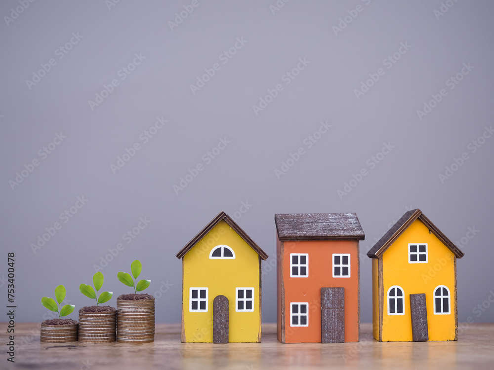 Miniature house and plants growing up on stack of coins. The concept of saving money for house, Property investment, House mortgage, Real estate. Miniature house and plants growing up on stack of coins. The concept of saving money for house, Property investment, House mortgage, Real estate.