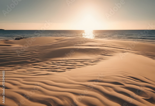 Serene beach sunrise with rippled sand dunes and calm ocean backdrop.