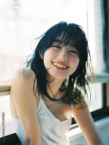窓辺の自然光を浴びる笑顔のアジア人女性 Free Download 窓辺の自然光を浴びる笑顔のアジア人女性 - GFXLoad