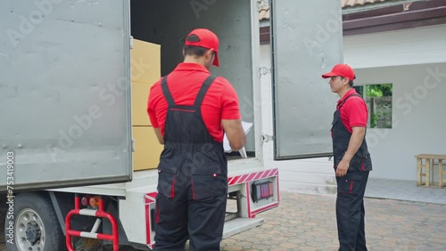 Two delivery men open the door in the back of truck containing boxes during move product to new house of customer.