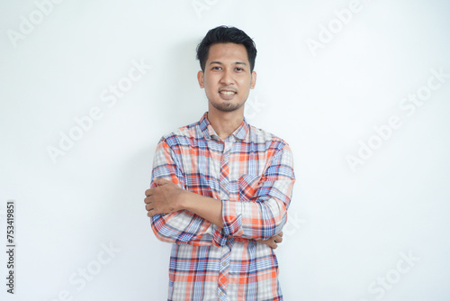 Adult Asian man standing confident with arms crossed showing happy expression photo