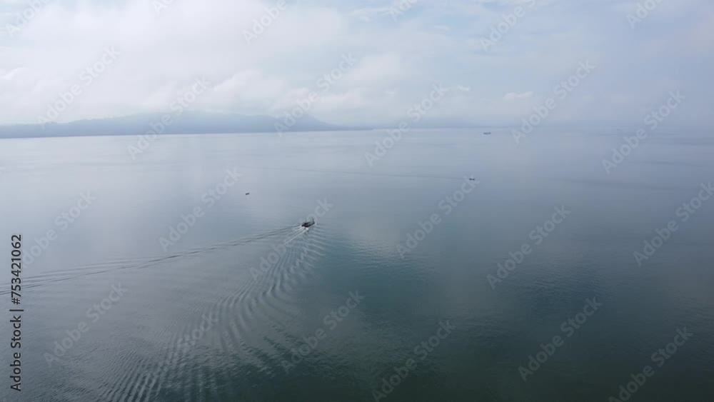 Aerial view of fishing boats sailing out to sea in search of fish Aerial view of fishing boats sailing out to sea in search of fish