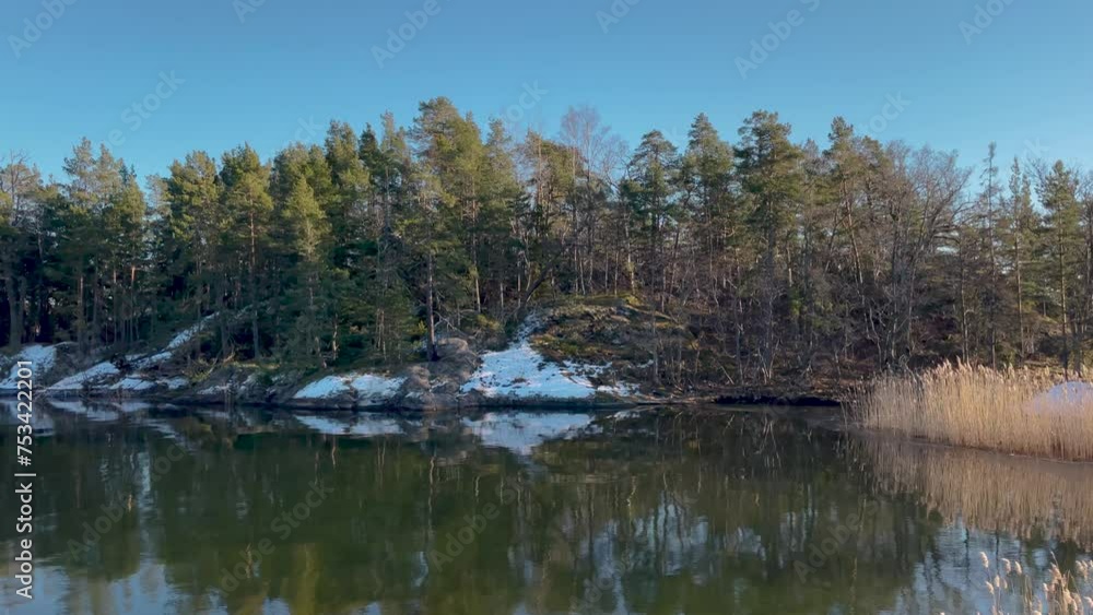 Tranquil winter scene of a snow-dusted island in Stockholm Archipelago, reflected on calm water Tranquil winter scene of a snow-dusted island in Stockholm Archipelago, reflected on calm water