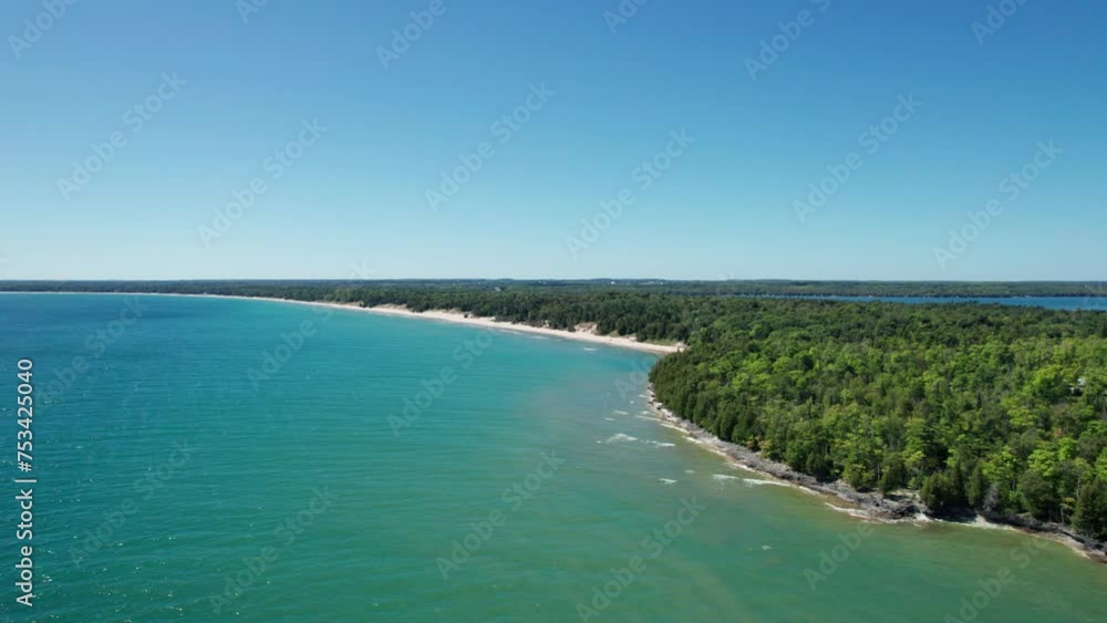 drone shot flying over lake Michigan towards whitefish dunes state park drone shot flying over lake Michigan towards whitefish dunes state park