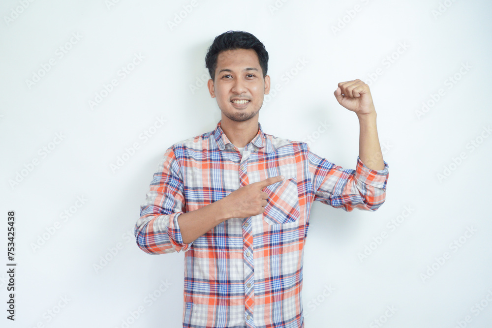 Adult Asian man smiling while pointing to his bicep muscle Adult Asian man smiling while pointing to his bicep muscle