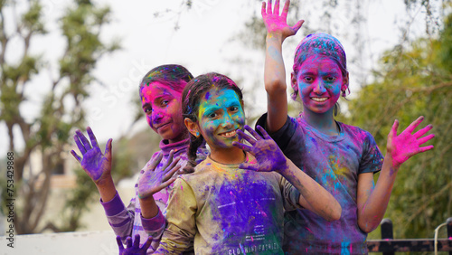 Indian cute happy child celebrate Indian holi festival with colorful paint powder on faces and body