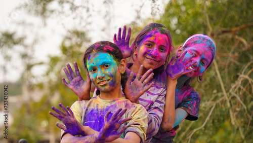 Happy Cute Smiling looking kids playing with paints in their fingers. Holi Festival of colors