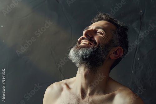 A man with a beard is smiling and laughing