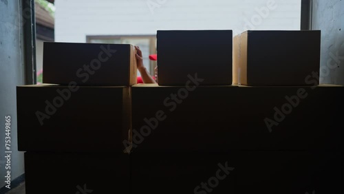 Two delivery men open the door in the back of truck containing boxes during move product to new house of customer.